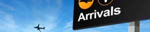 Airport arrivals sign and aeroplane in sky